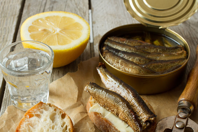 Vaso de chupito de vodka y sardinas